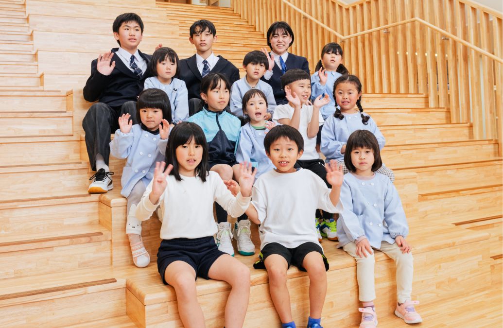 地域交流スペースの⼤階段に集った園児・児童・⽣徒たち。大階段は子どもたちの発表の場としても活用。